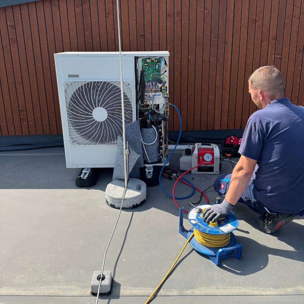 Techniker repariert Klimaanlage auf Flachdach.