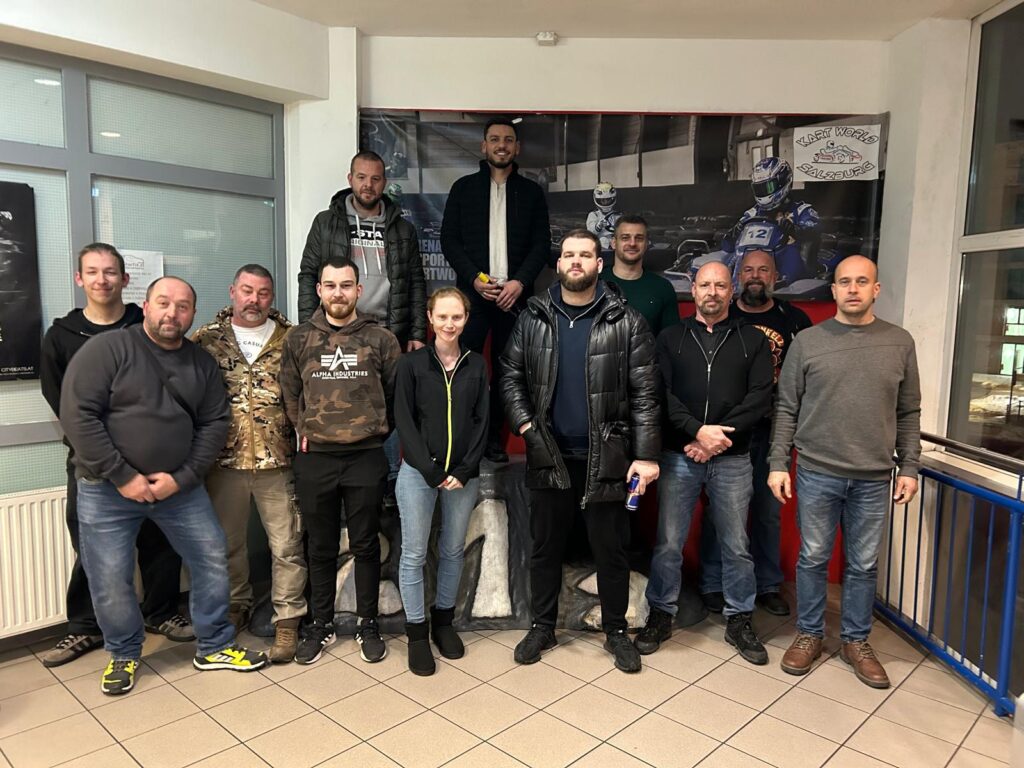 Gruppe von Menschen posiert für ein Foto drinnen.