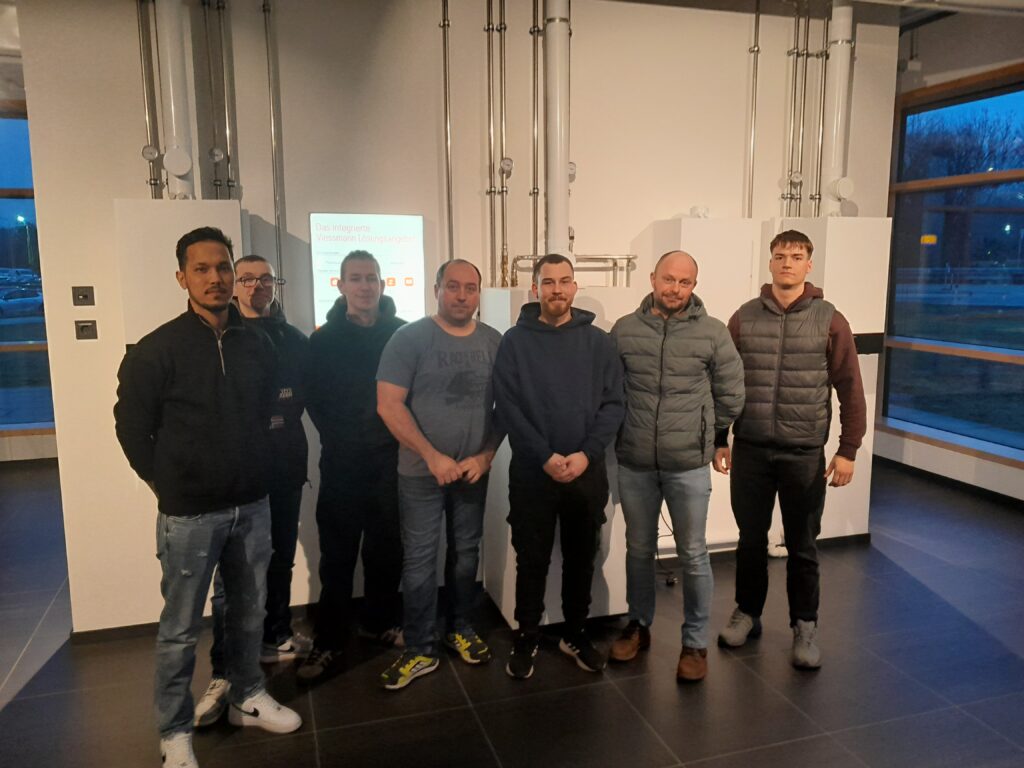 Gruppe von sieben Männern in einem Büro.